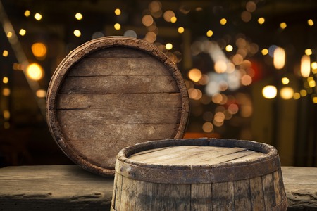Oktoberfest beer barrel and beer glasses with wheat and hops on wooden table