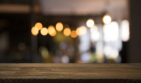 blurred background of bar and dark brown desk space of retro wood
