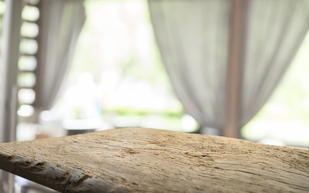 Empty of wood table top on blur of curtain with window view green from tree garden background.For montage product display or design key visual layoutの写真素材
