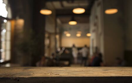 image of wooden table in front of abstract blurred background of resturant lightsの写真素材
