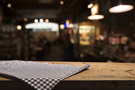 Table background with napkin and blurred bar background spaceの写真素材