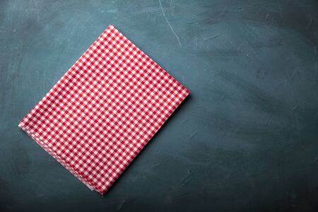 Empty wooden deck table and red checked tablecloth over mint wallpaper backgroundの写真素材