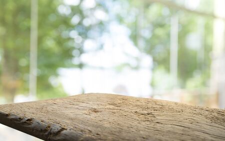 Empty of wood table top on blur of curtain with window view green from tree garden background.For...