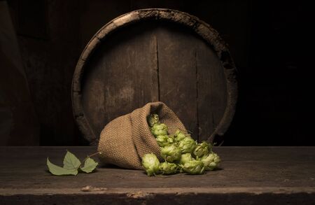 Oktoberfest beer barrel and beer glasses with wheat and hops on wooden tableの写真素材