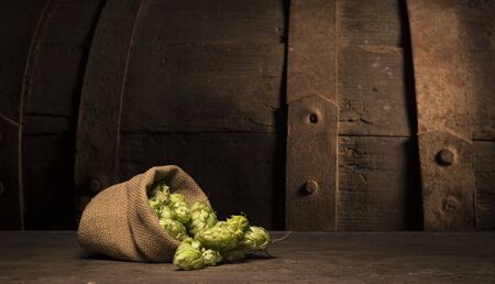 Oktoberfest beer barrel and beer glasses with wheat and hops on wooden tableの写真素材