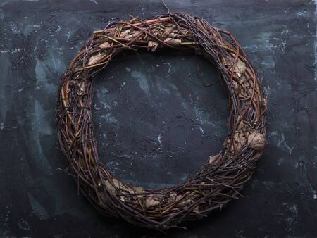 Rustic wreath made a twigs and branches on simple wooden background with pine cone and evergreen branches. Christmas image with space for textの写真素材