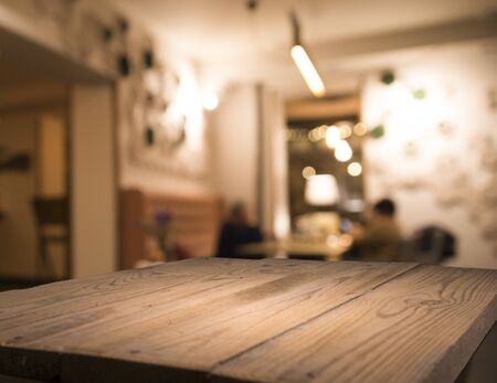 blur bokeh reflection light on table in pub or bar club and restaurant Christmas party and celebrate at dark night for display product in brown tone backgroundの写真素材