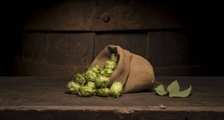 Oktoberfest beer barrel and beer glasses with wheat and hops on wooden tableの写真素材