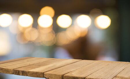 Empty brown wooden table and blur background of abstract of resturant lights people enjoy eating...