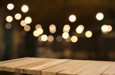Empty brown wooden table and blur background of abstract of resturant lights people enjoy eating...