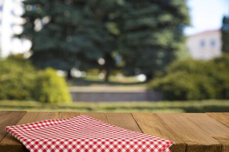 Empty wooden deck table with foliage bokeh background. Ready for product display montage.の写真素材