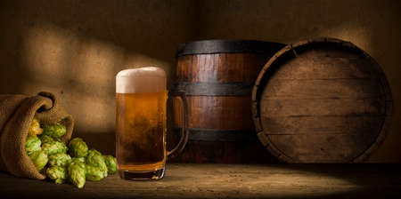 Beer style- bottle, beer in the glass and covers on wooden table. Free space for text. Top view