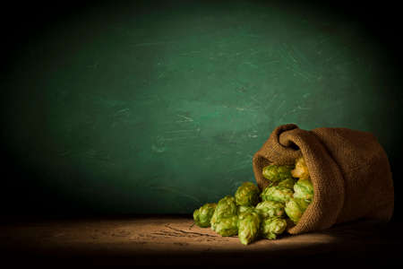 Beer style- bottle, beer in the glass and covers on wooden table. Free space for text. Top view