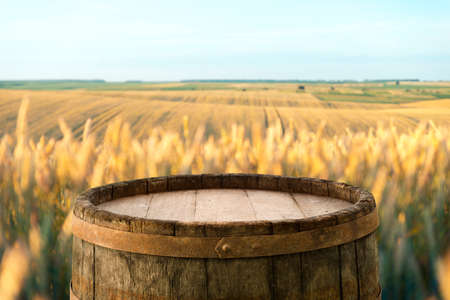Empty wooden deck table over wheat field with sunset or sunrise. Ready for product montageの写真素材