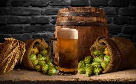 Beer barrel with beer glasses on a wooden table. The dark brown background.の写真素材