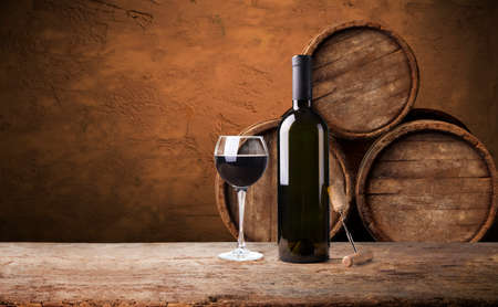 the still life with red wine, bottle, glass and old barrelの写真素材