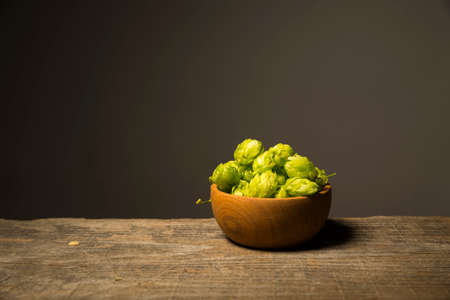 Beer. Still life with Vintage beer barrel and glass light beer. Fresh amber beer concept. Green hop...