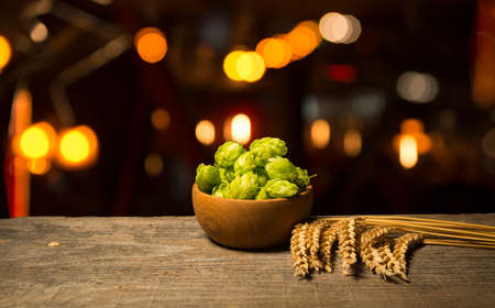 Beer. Still life with Vintage beer barrel and glass light beer. Fresh amber beer concept. Green hop...