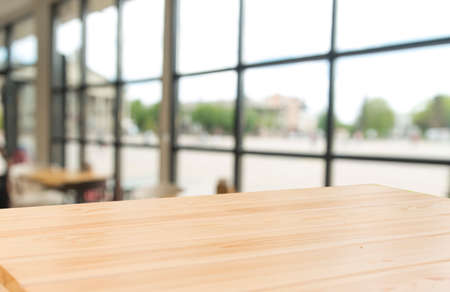 Empty wooden table top with lights bokeh on blur restaurant background.の写真素材
