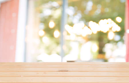 Empty wooden table top with lights bokeh on blur restaurant background.の写真素材