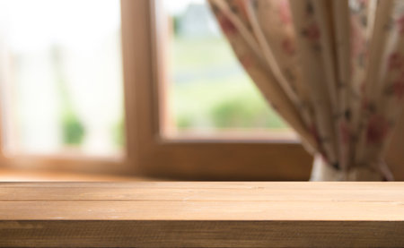 Wooden white table in home interior and white window with fall landscapeの写真素材