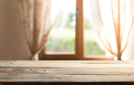 Wooden white table in home interior and white window with fall landscapeの写真素材