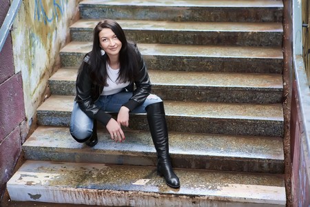 Young sexy woman crouching on the stairの写真素材