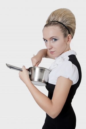 Beautiful young woman with a fancy hairdo cookingの写真素材