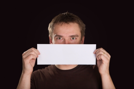 Man with blank paper in front of his faceの写真素材