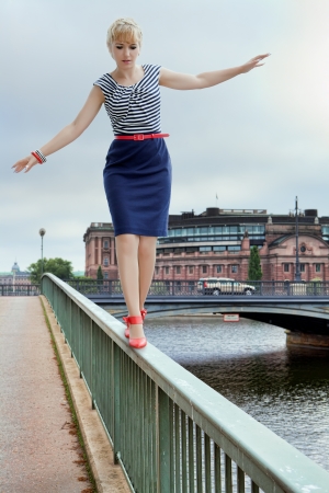 Woman balancing on a bridge railingの写真素材
