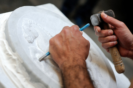 Stone mason at work carving an ornamental reliefの写真素材