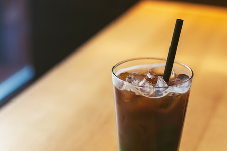 Ice coffee wich blue green cocktailcold coffee and green, blue syrup. Summer refreshing cocktail on wooden table in a coffee house, restaurant.の写真素材