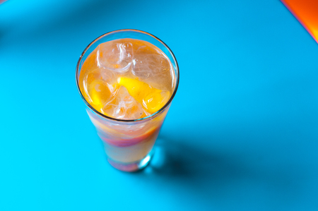 Orange juice on blue wooden background, top view. Closeup glass of cocktailの写真素材