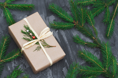 Christmas gift wrapped in craft paper on dark concrete background. Flat lay, top view, copy spaceの写真素材