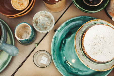 Ceramic tableware and cutlery on wooden background. Ð¡oncept pottery of different colors. Top view, flatlay, Ñopy space for text.の写真素材