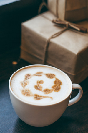 cappuccino latte coffee art in cup on old wooden loft style desk , soft focus with dark toneの写真素材