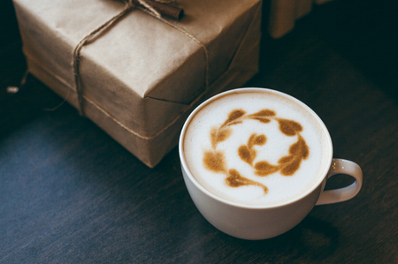 cappuccino latte coffee art in cup on old wooden loft style desk , soft focus with dark toneの写真素材