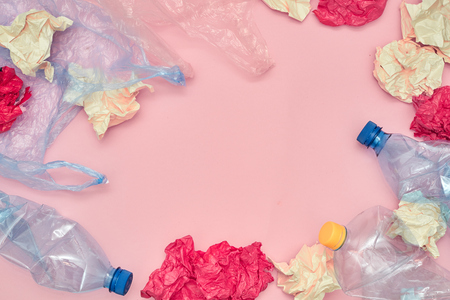Plastic bags of used, paper and bottles on pink background. Eco friendly concept. Copy space. Flat...