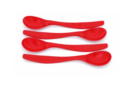 four children's spoons laid out in parallel on a white backgroundの写真素材