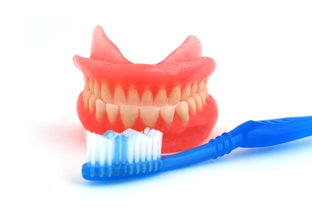 dentures and toothbrush on white backgroundの写真素材