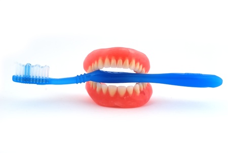 dentures and toothbrush on white backgroundの写真素材