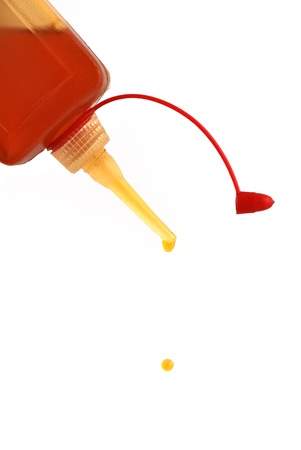 falling drops of oil can on a white backgroundの写真素材