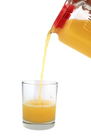 orange juice is poured into a glass carafeの写真素材