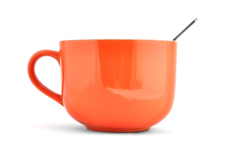 empty orange cup and spoon on a white backgroundの写真素材