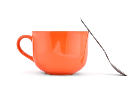 empty orange cup and spoon on a white backgroundの写真素材