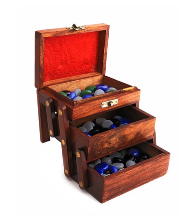 wooden box with colored stones on a white backgroundの写真素材