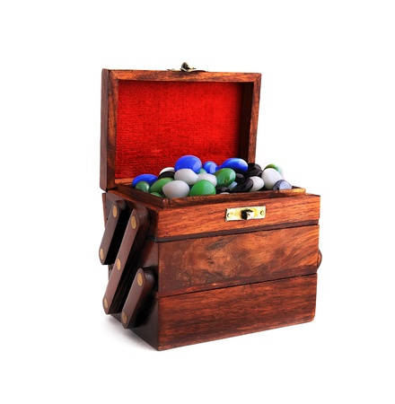 wooden box with colored stones on a white backgroundの写真素材