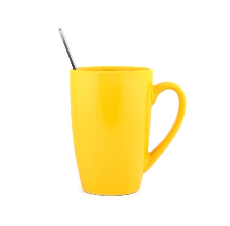 empty yellow cup and spoon on a white backgroundの写真素材