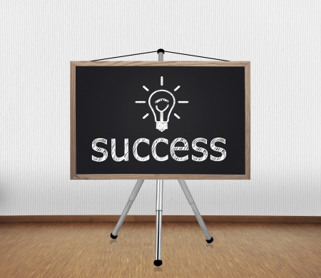 blackboard with drawing success on tripod standing in officeの写真素材