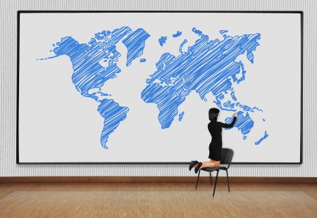 woman standing on a chair and drawing world mapの写真素材
